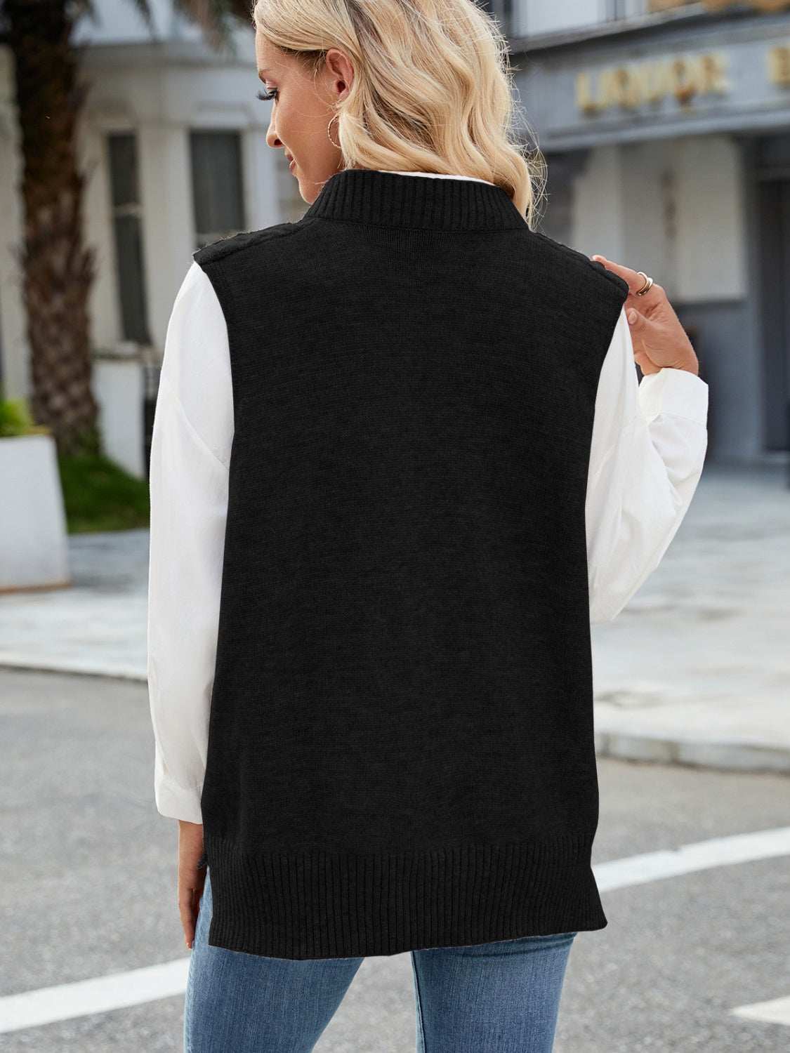 Cable knit V-neck sweater vest in black, 100% acrylic, slightly stretchy, back view.