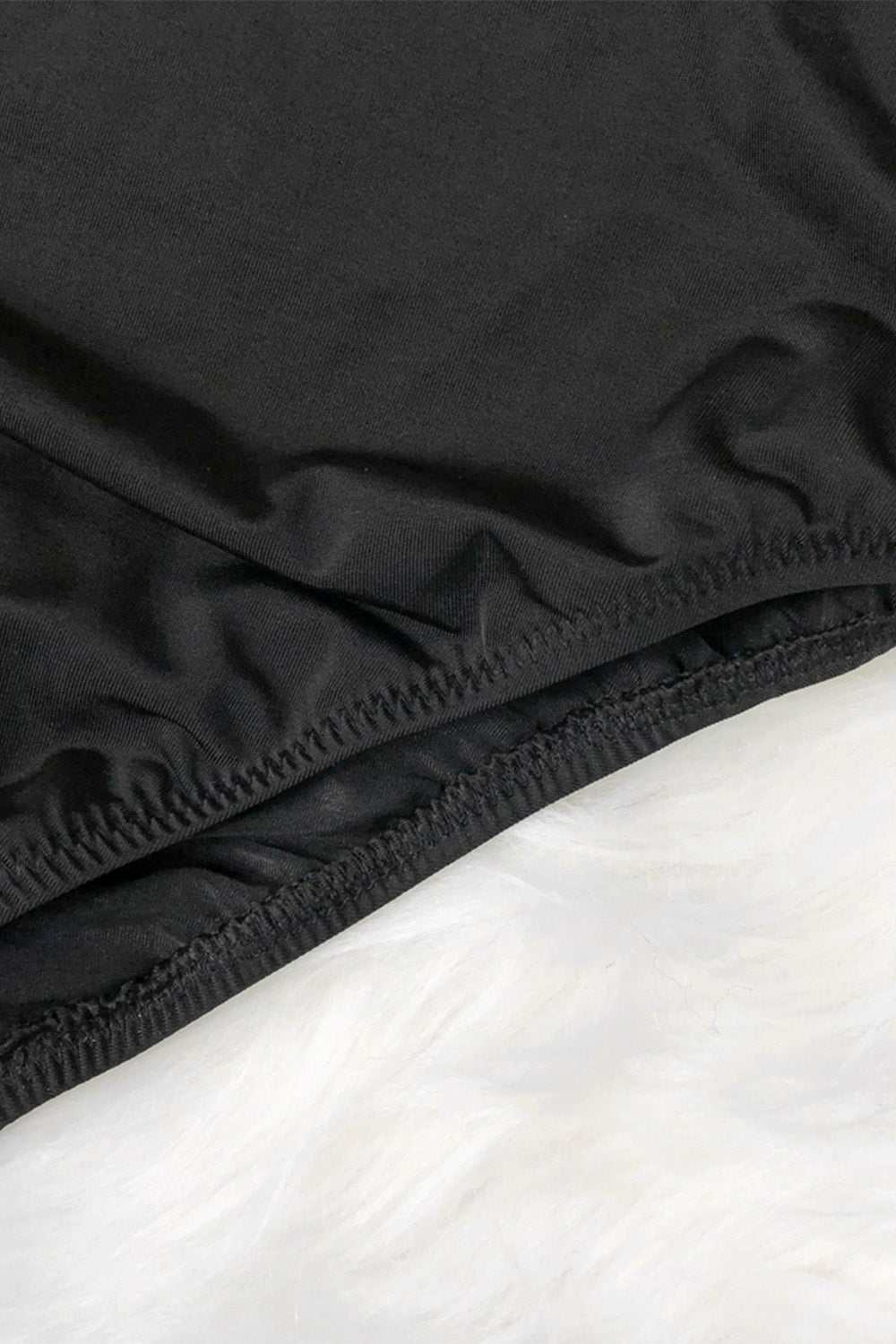 Mock neck long sleeve swimwear, black fabric detail, stretchy material.