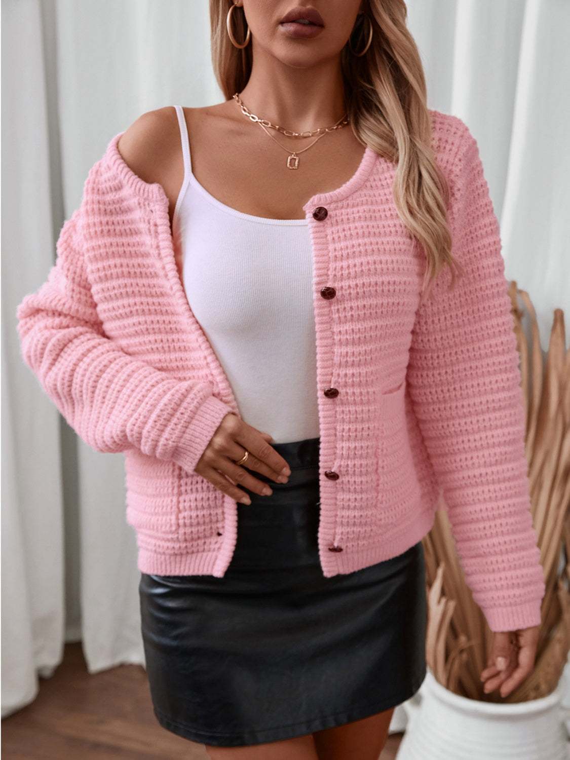 Pink button-up long sleeve cardigan with pockets, worn over a white top.