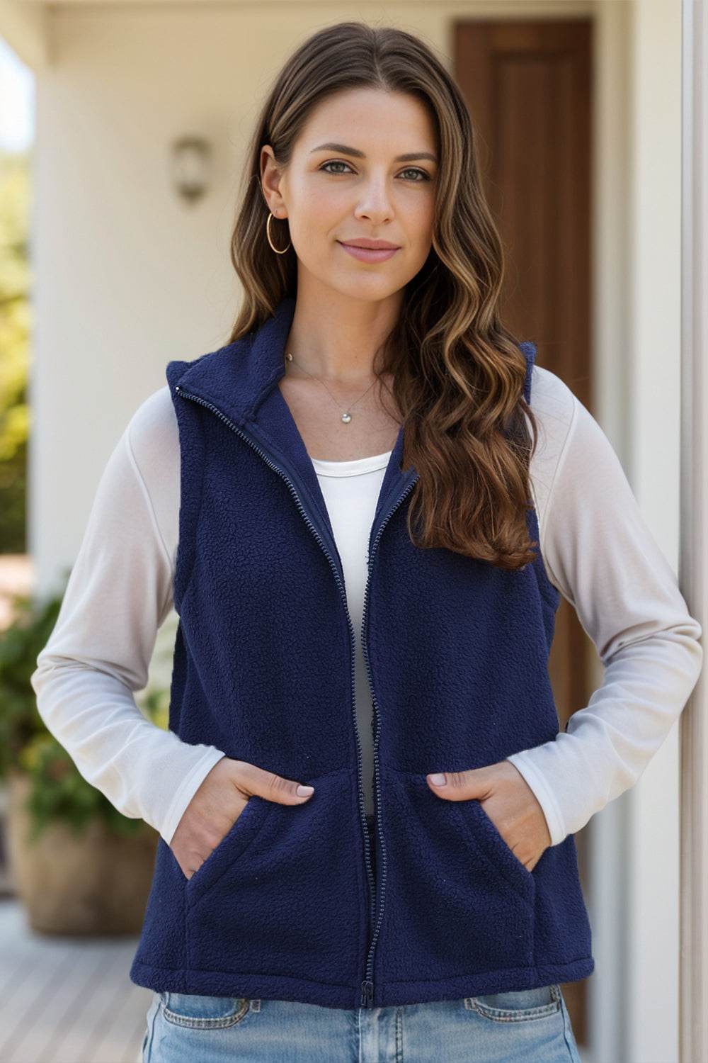 Women's navy blue zip-up vest coat with pockets, unlined, made from 95% polyester and 5% spandex.