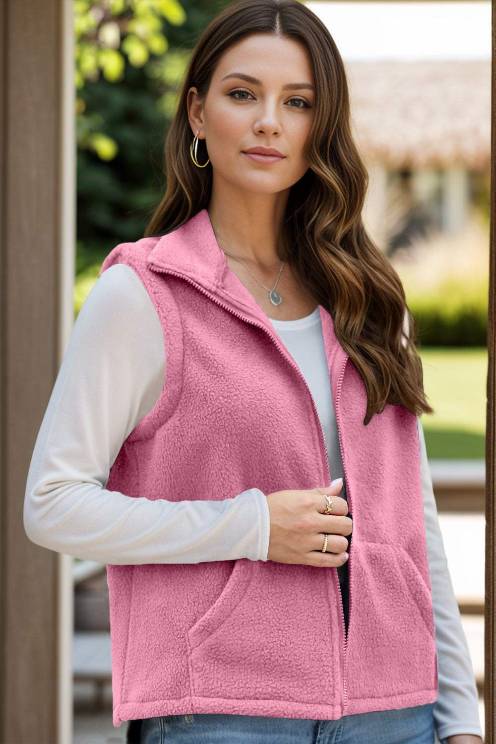 Pink zip up vest coat with pockets, made of polyester and spandex.