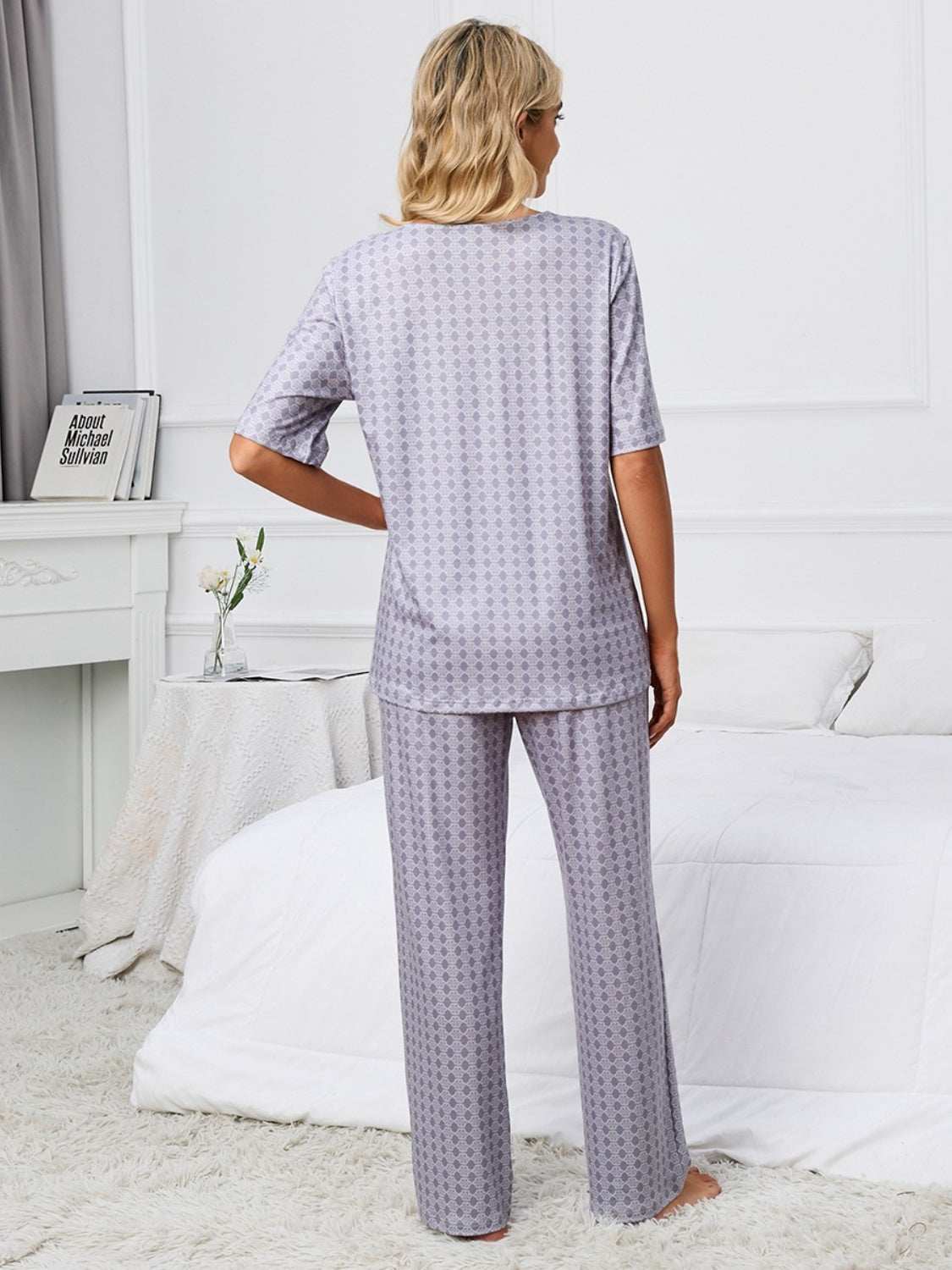 Printed V-neck top and pants lounge set in gray, standing in a bedroom setting.