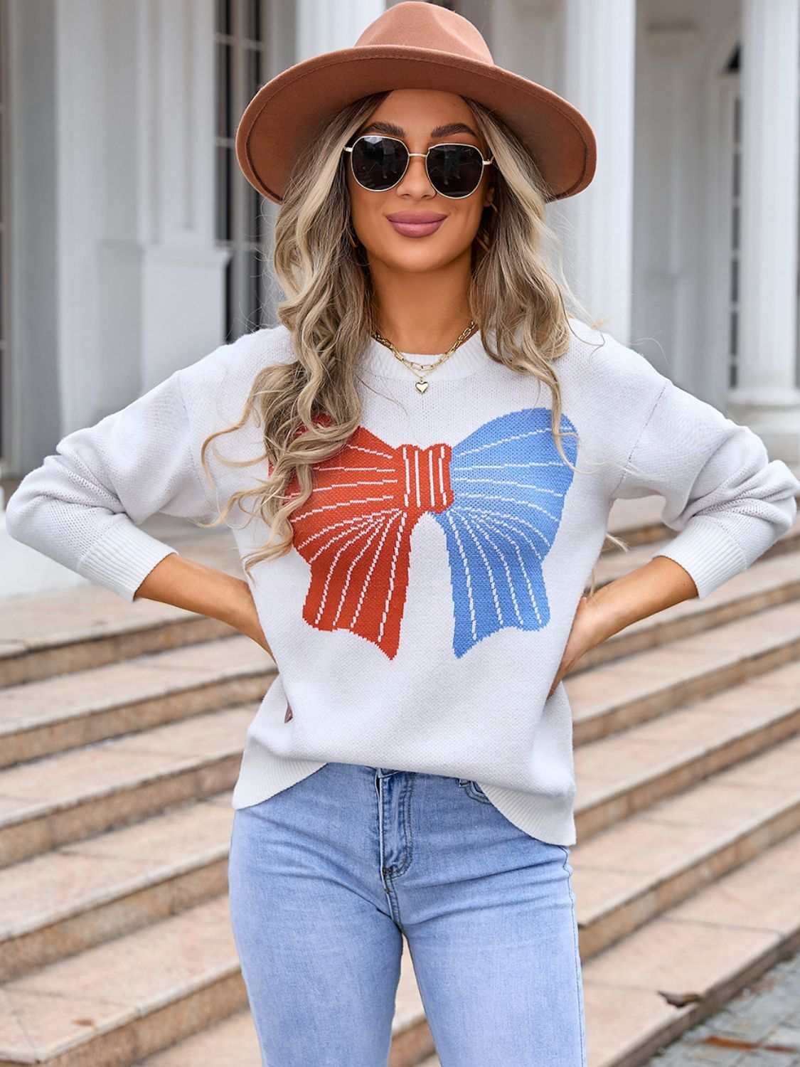 Angel Wings Bow Round Neck Dropped Shoulder Sweater in white with colorful bow design, worn by a woman outdoors.