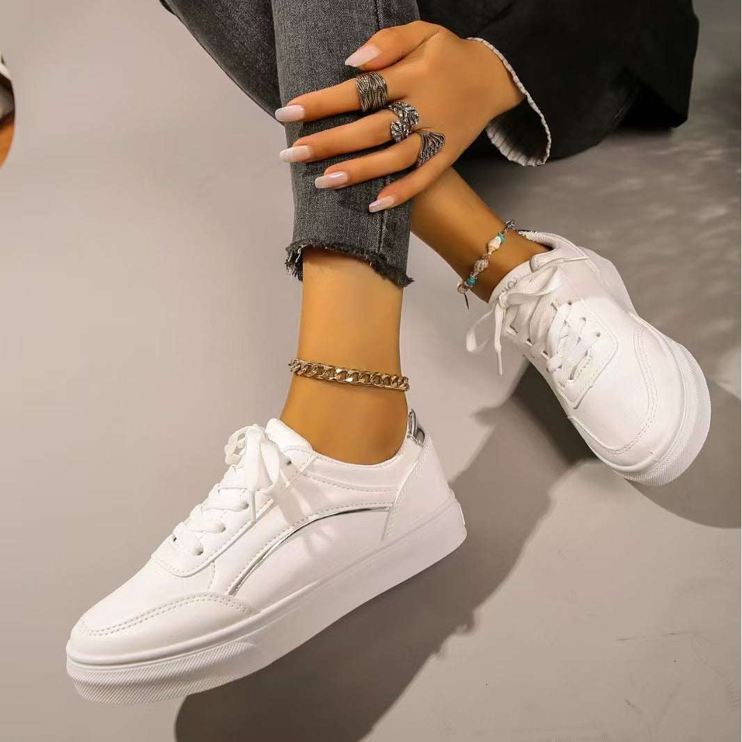 PU Leather Round Toe Flat Sneakers in white, shown on person's feet.