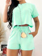 Full size round neck short sleeve top and shorts set, mint color, two-piece outfit with pockets and tie detail.