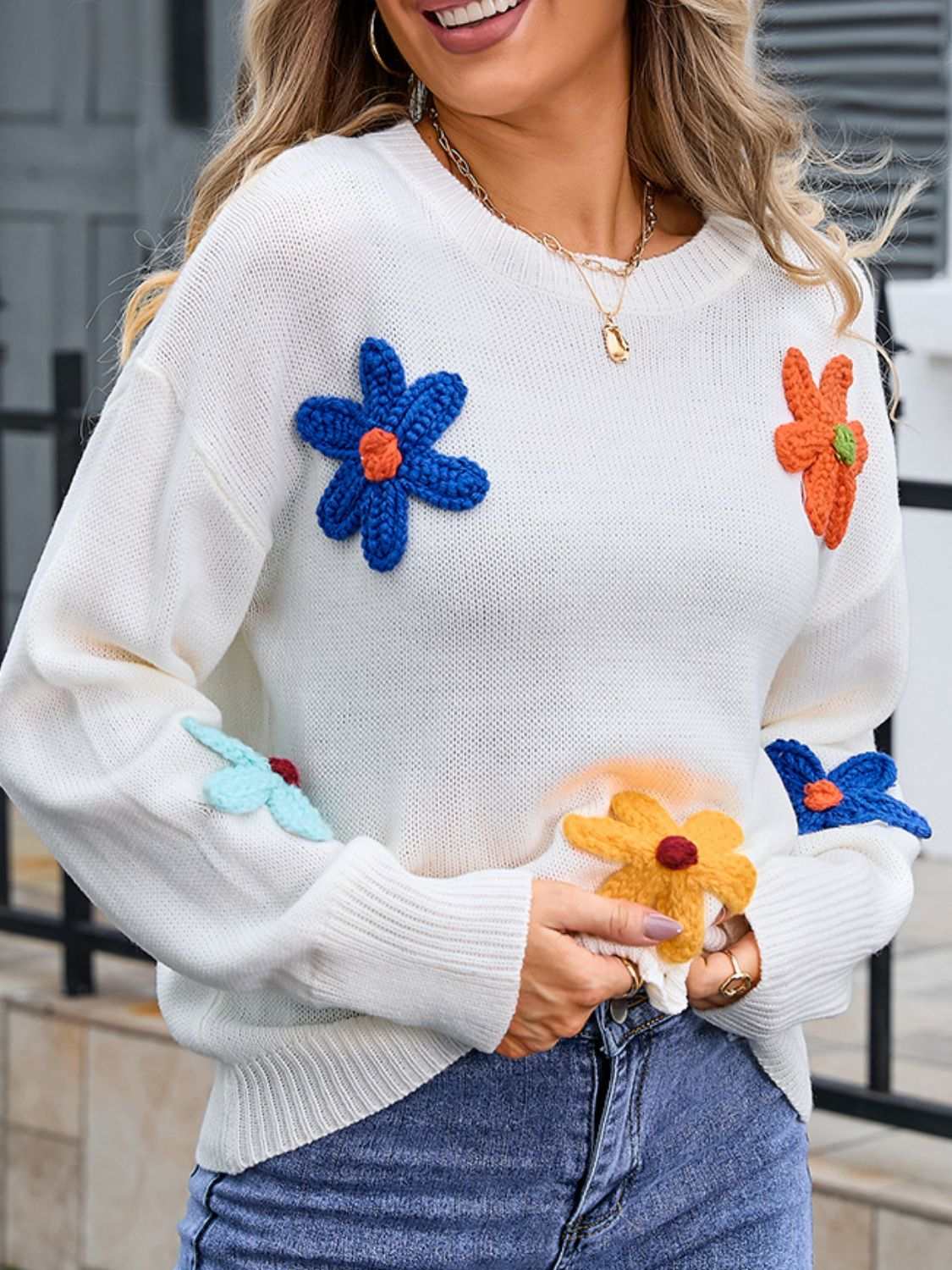 Women's round neck sweater with crochet flower design and angel wings pattern, moderate stretch, 100% acrylic material.