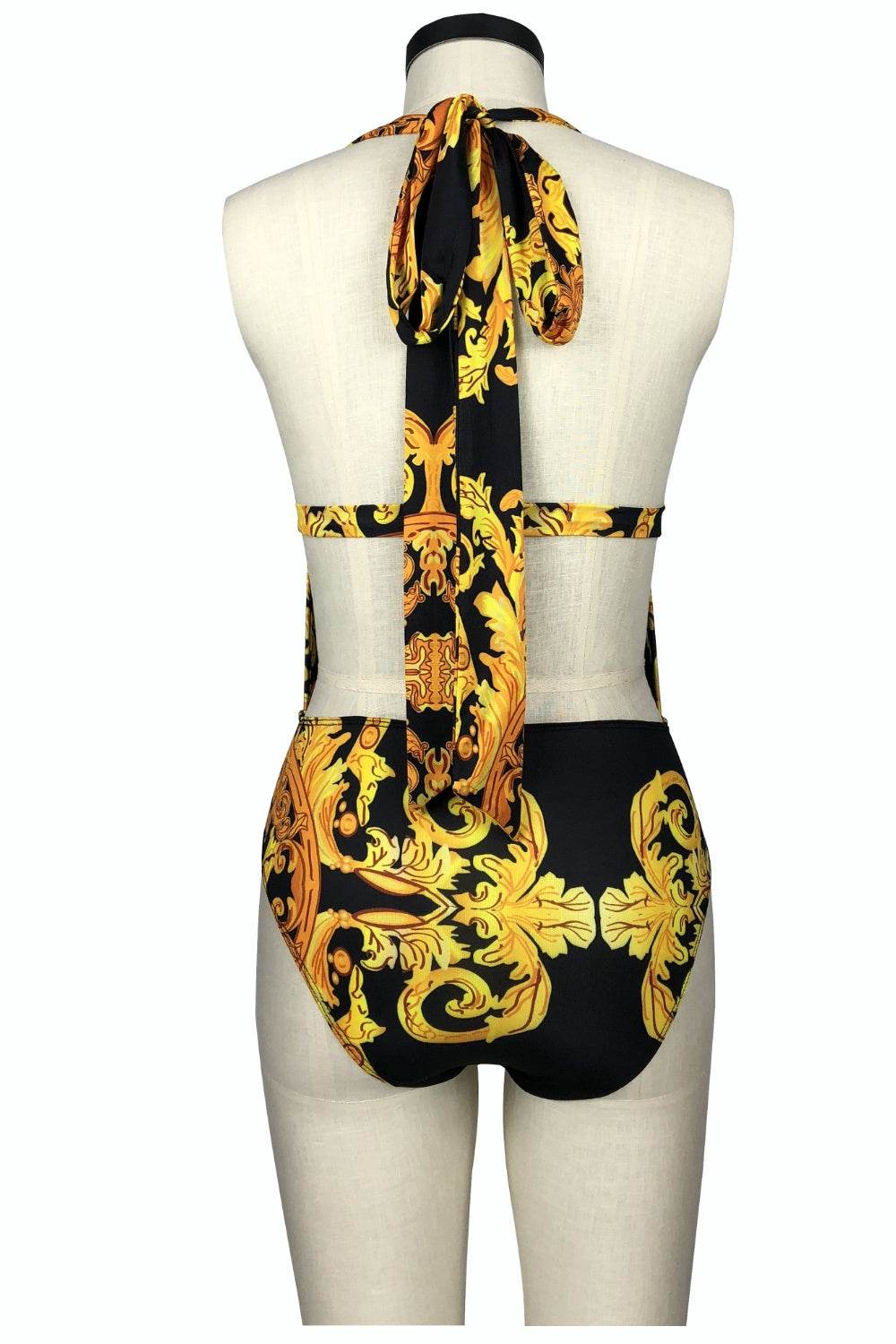 Printed plunge one-piece and cover-up swim set with yellow floral design on black background.