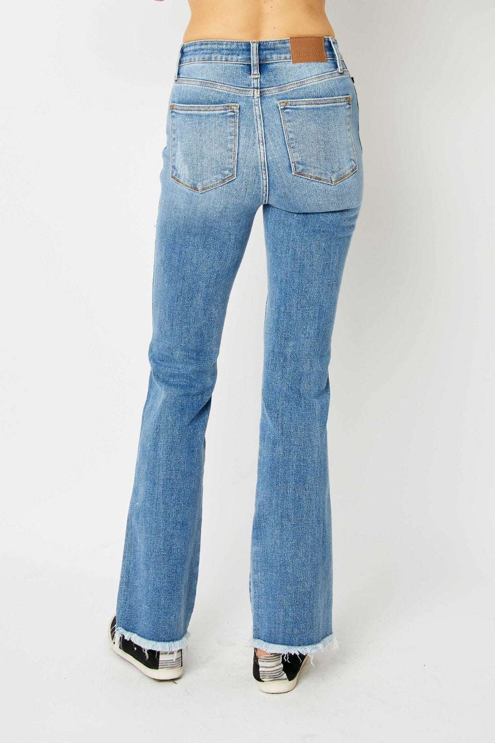 Judy Blue full size distressed raw hem bootcut jeans featuring a classic silhouette with edgy details.