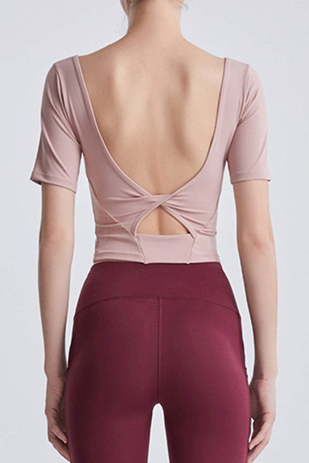 Back view of a woman wearing a cutout backless round neck active t-shirt.