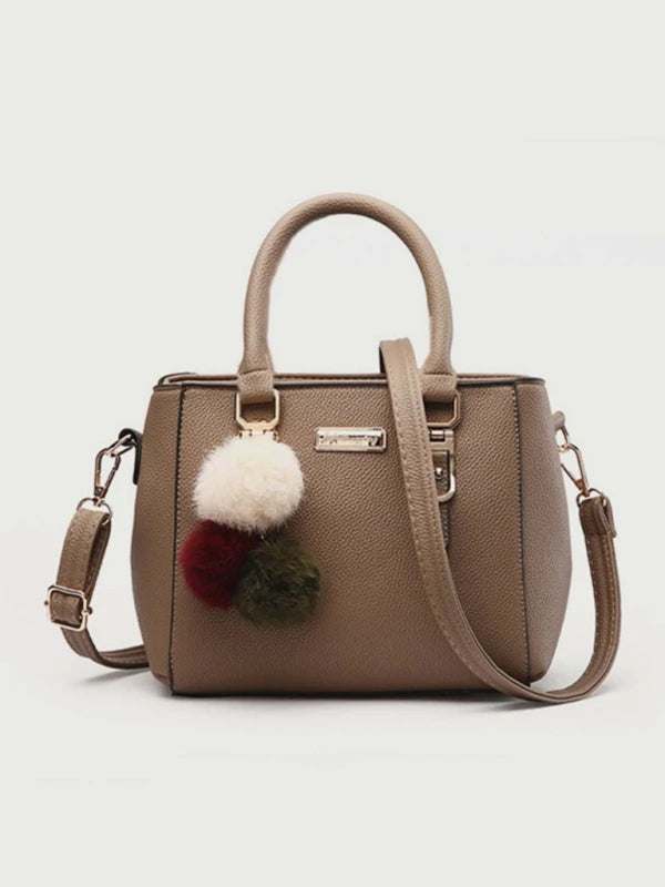 Fashionable women's all-match shoulder bag in PU leather with pom pom accents.