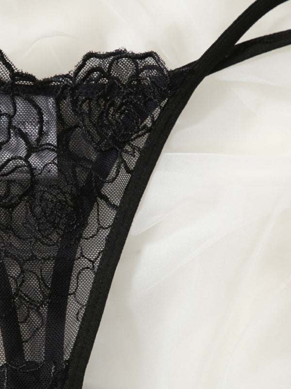 Black thin hollow lace bra with floral design on white fabric background.